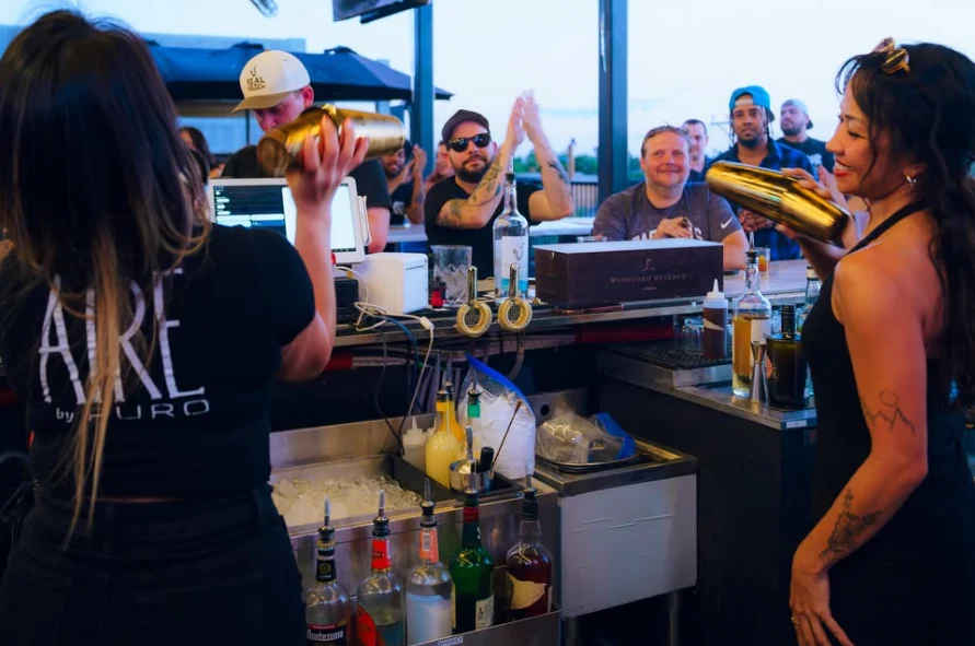 Bartenders shaking cocktails for guests at the rooftop bar